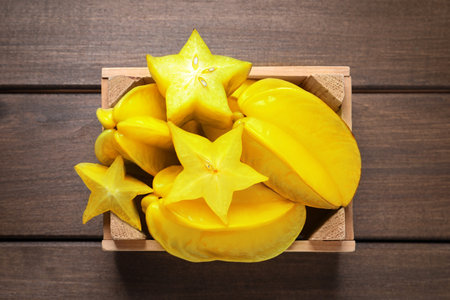 Delicious carambola fruits on wooden table, top viewの写真素材