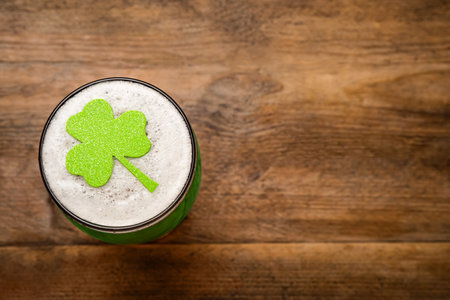 Top view of beer with clover leaf on wooden table, space for text. St Patrick's Day celebrationの写真素材