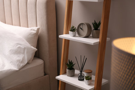 Stylish bedroom interior with decorative ladder and plants near gray wallの写真素材