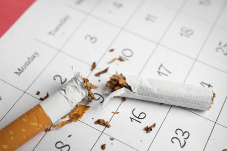 Calendar sheet with broken cigarette, closeup. Quitting smoking conceptの写真素材