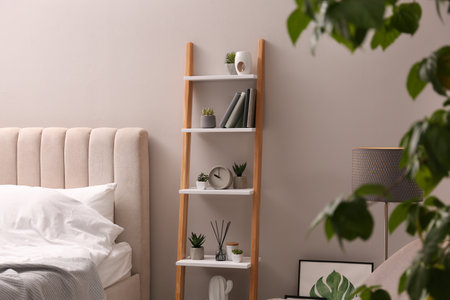 Stylish bedroom interior with decorative ladder and plants near gray wallの写真素材