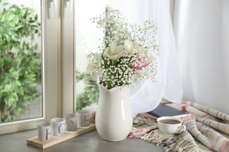 Beautiful fresh flowers on window sill indoorsの写真素材