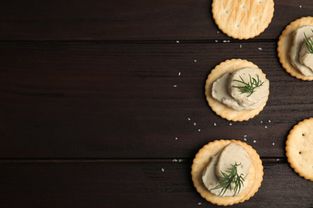 Delicious crackers with humus and dill on wooden table, flat lay. Space for textの写真素材