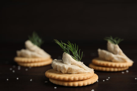 Delicious crackers with humus and dill on wooden tableの写真素材