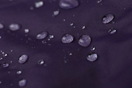 Purple waterproof fabric with water drops as background, closeupの写真素材