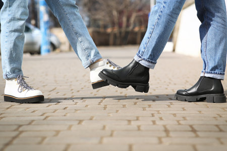 People greeting each other by bumping feet instead of handshake outdoors, closeupの写真素材