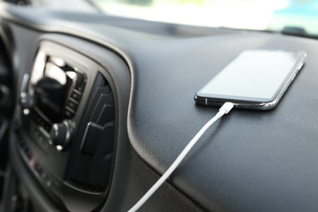 Smartphone with USB charging cable in modern carの写真素材