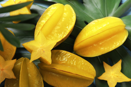 Delicious carambola fruit and green leaf on tableの写真素材