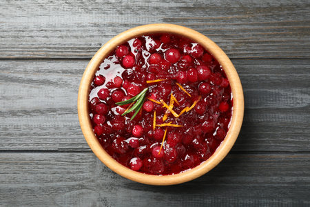 Fresh cranberry sauce with orange peel and rosemary on gray wooden table, top viewの写真素材