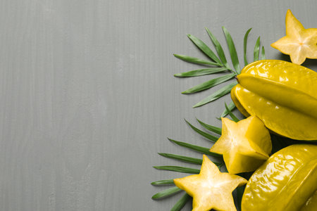 Delicious carambola fruits on gray wooden table, flat lay. Space for textの写真素材