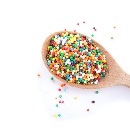 Colorful sprinkles in spoon on white background. Confectionery decorの写真素材