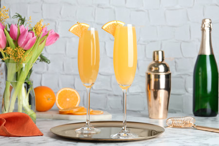Glasses of Mimosa cocktail with garnish on white marble tableの写真素材