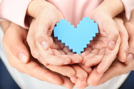 Parents and kid holding blue heart in hands, closeup. family dayの写真素材
