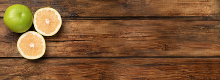 Whole and cut sweetie fruits on wooden table, flat lay with space for text. banner design