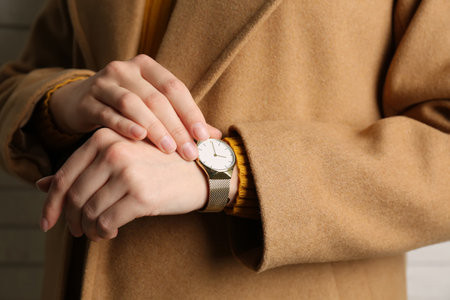 Woman wearing luxury wristwatch near white brick wall, closeupの写真素材