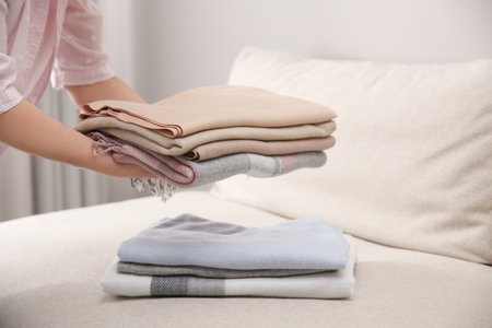 Woman with folded cashmere clothes indoors, closeupの写真素材