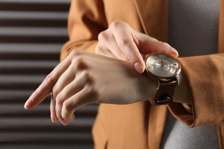 Woman wearing luxury wristwatch on dark gray background, closeupの写真素材