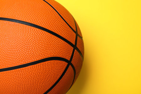 Orange ball on yellow background, top view with space for text. basketball equipmentの写真素材