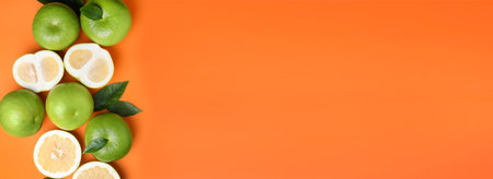 Fresh ripe sweeties and green leaves on orange background, flat lay with space for text. banner designの写真素材