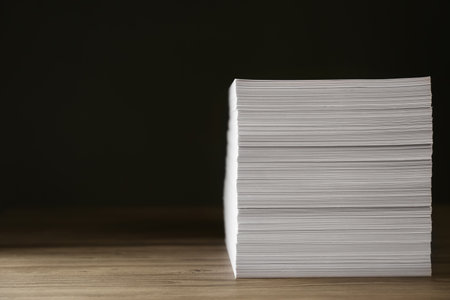 Stack of paper sheets on wooden table. Space for text