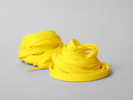 Yellow shoe laces on light gray backgroundの写真素材