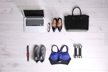 Flat lay composition of business items with sport accessories on white wooden background. Life and work balance conceptの写真素材
