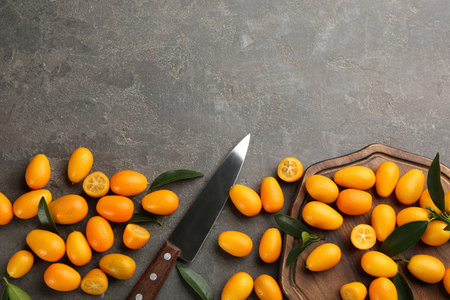 Fresh ripe kumquats on gray table, flat lay. Space for textの写真素材
