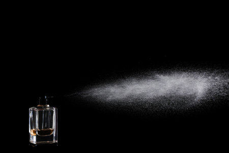 Woman spraying luxury perfume on black background, closeupの写真素材