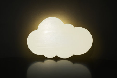 Cloud shaped glowing night lamp on black backgroundの写真素材