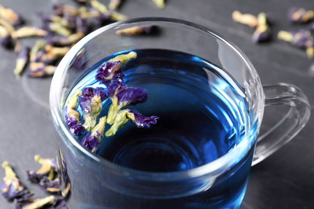 Glass cup of organic blue Anchan on black table, closeup. herbal teaの写真素材