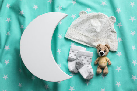 Flat lay composition with crescent shaped child's night lamp on turquoise fabricの写真素材