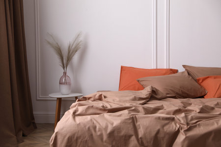 Bed with orange and brown lines in stylish roomの写真素材