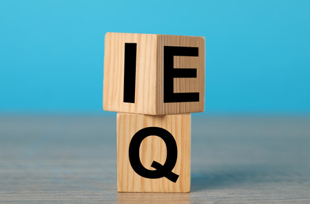 Wooden cubes with letters E, I and Q on tableの写真素材