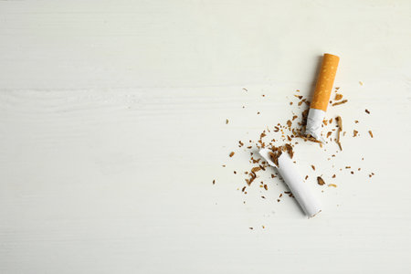 Broken cigarette on white table, flat lay with space for text. Quitting smoking conceptの写真素材
