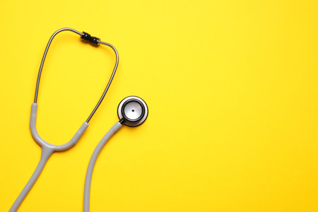 Stethoscope on yellow background, top view. Space for textの写真素材