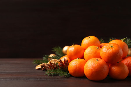Fresh tangerines with fir tree branches on dark wooden table, space for text. christmas atmosphereの写真素材