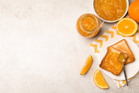 Delicious orange marmalade and toasts on light table, flat lay. Space for textの写真素材