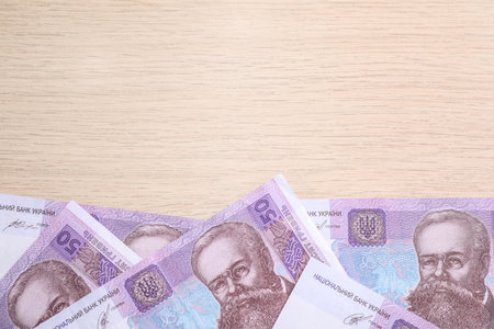 Ukrainian money on wooden background, flat lay. Space for text
