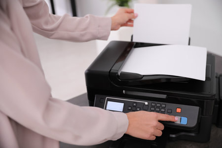 Employee using modern printer in office, closeupの写真素材