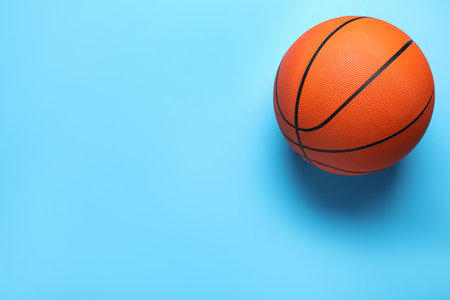 Orange ball on light blue background, top view with space for text. basketball equipmentの写真素材