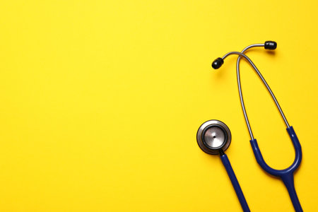 Stethoscope on yellow background, top view. Space for textの写真素材