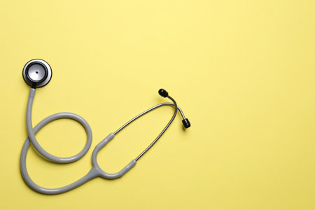 Stethoscope on yellow background, top view. Space for textの写真素材