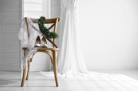 Pair of white high heel shoes, veil and wedding dress indoors. Space for textの写真素材