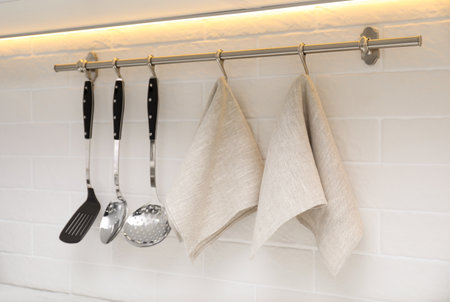 Kitchen utensils and clean towels hanging on wall indoorsの写真素材