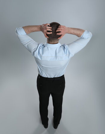 Man in formal clothes on gray background, back viewの写真素材