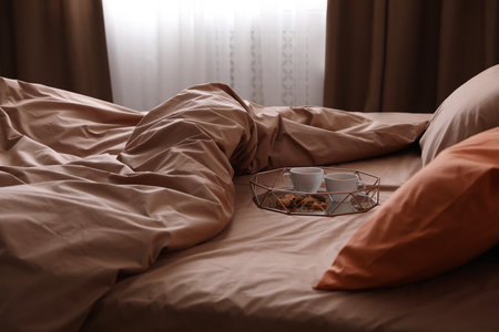 Bed with orange and brown lines in stylish roomの写真素材