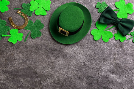 Leprechaun's hat and St. Patrick's day decor on gray stone background, flat lay. Space for text