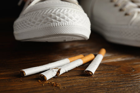 Woman stepping on pile of cigarettes, closeup. Quitting smoking conceptの写真素材