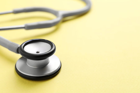 Stethoscope on yellow background, closeup. Space for textの写真素材