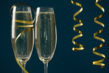 Glasses of champagne and serpentine streamers on dark blue background, closeupの写真素材